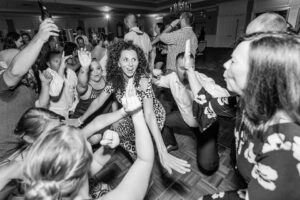 A live group of people dancing on the dance floor at a wedding.