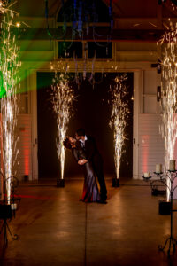 A bride and groom kissing in front of sparklers at their photo booth rental.
